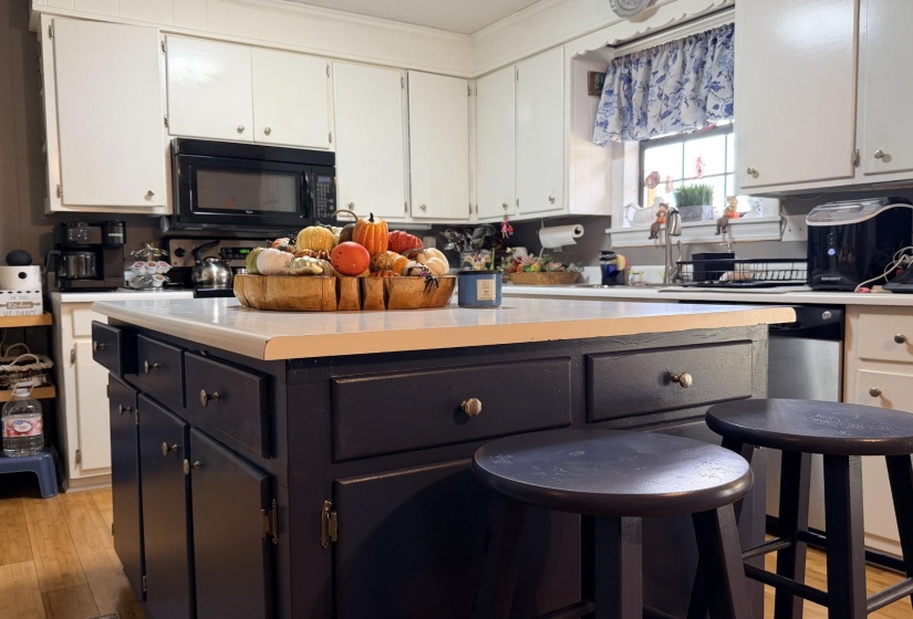 Kitchen with light wood finished floors, light countertops, and a center island