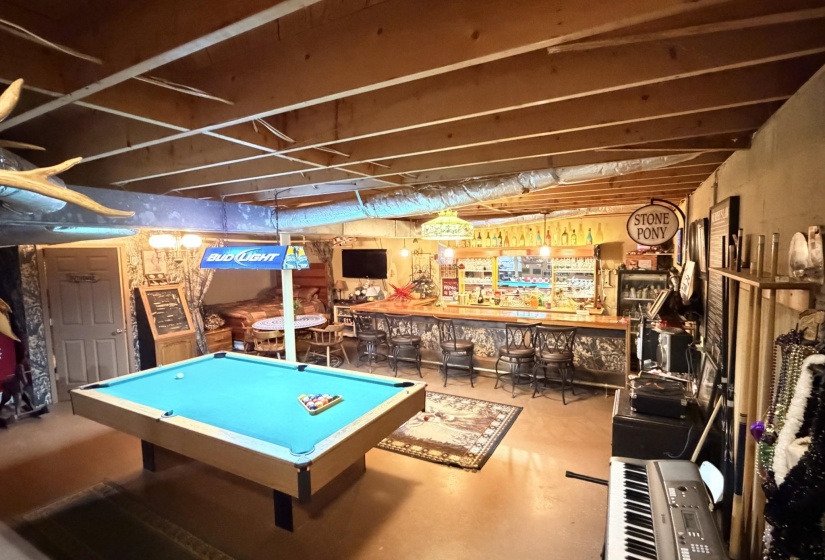 Rec room featuring pool table, a dry bar, and finished concrete flooring