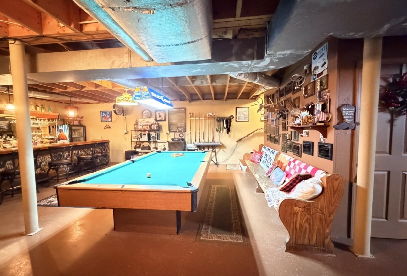 Game room featuring billiards table, a bar, and concrete floors