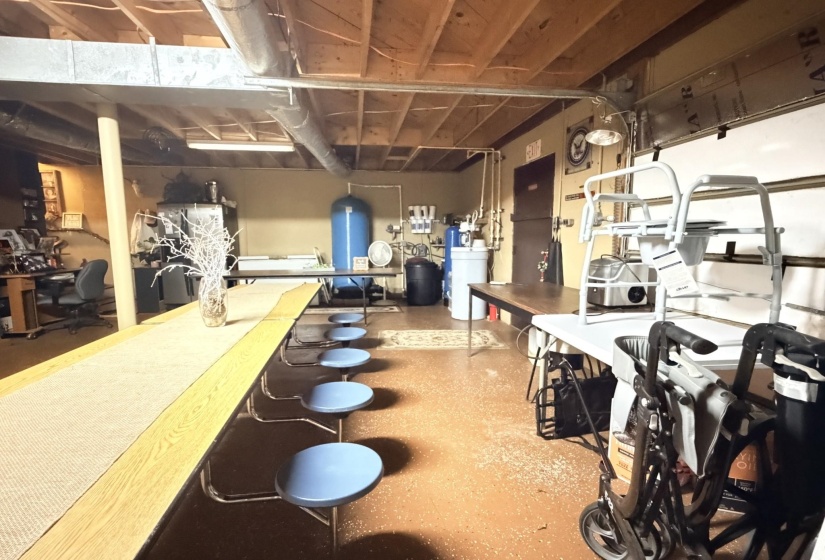 Below grade area featuring a desk, a water softener, and a water pressure tank