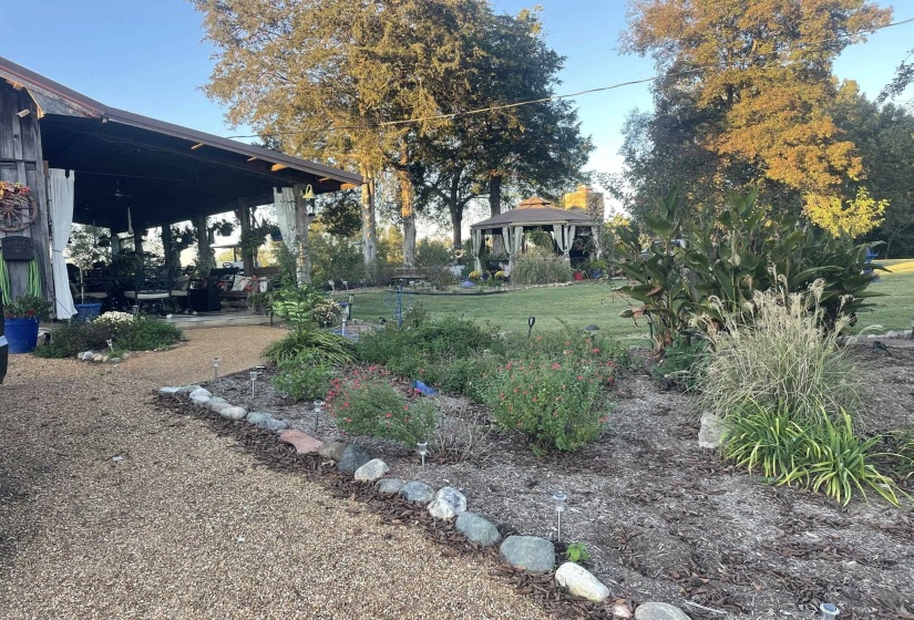 View of grassy yard featuring a gazebo and a patio