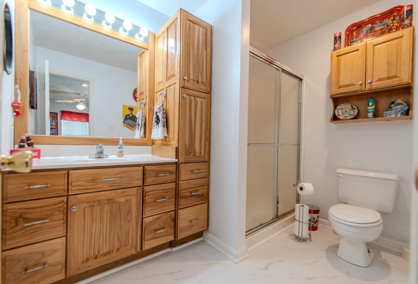 Bathroom with vanity, light marble finish flooring, and a stall shower