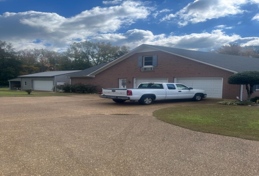 View of side of home featuring brick siding and driveway