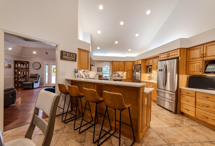 Kitchen featuring a kitchen breakfast bar, freestanding refrigerator, recessed lighting, a peninsula, and stainless steel fridge with ice dispenser