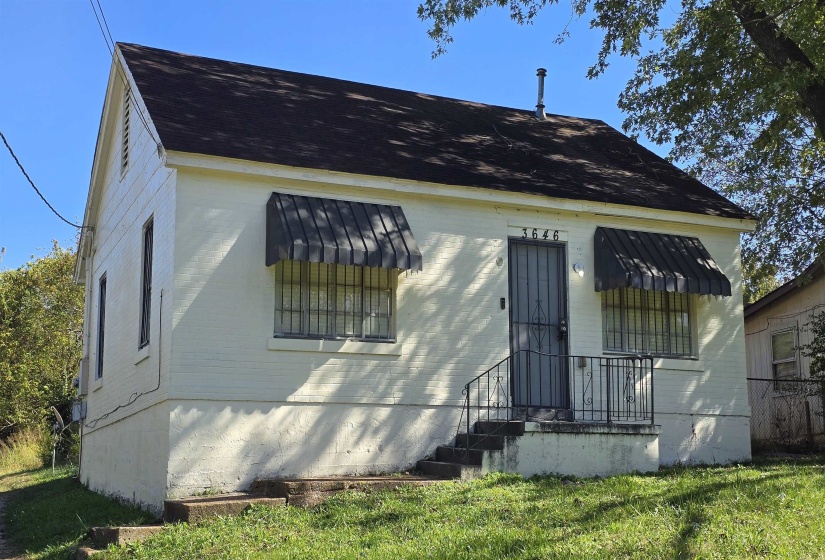 View of front of home featuring a shingled roof and a front lawn