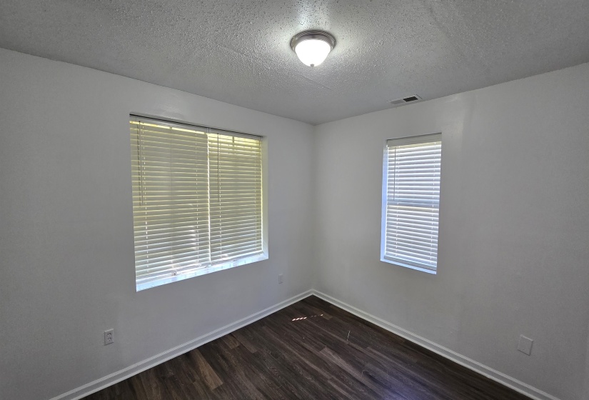 Spare room with dark wood-style floors and a textured ceiling