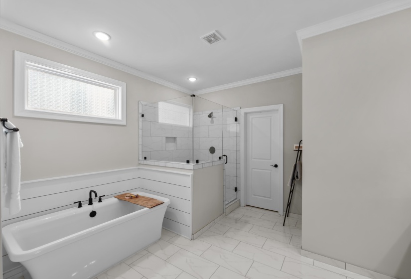 Full bath featuring a freestanding tub, a shower stall, marble look tile flooring, ornamental molding, and recessed lighting