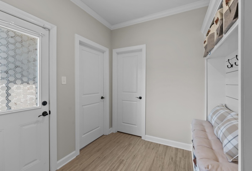Mudroom with ornamental molding and light wood finished floors