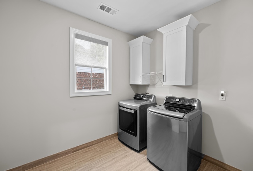 Laundry room featuring cabinet space, washer and clothes dryer, and light wood-style flooring