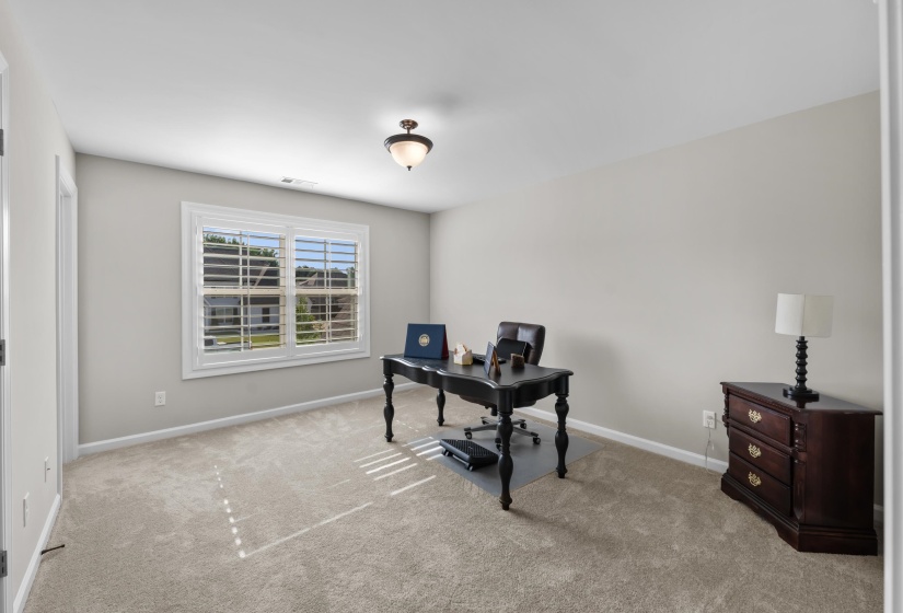Carpeted home office featuring baseboards