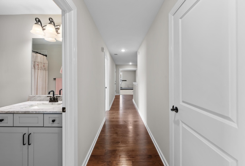 Corridor with dark wood-type flooring and recessed lighting