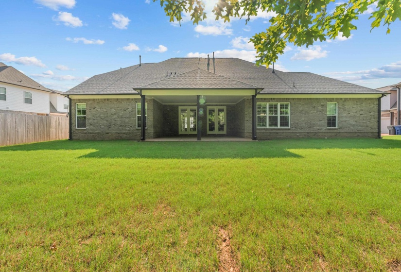 Back of property featuring french doors, brick siding, a patio, and a shingled roof