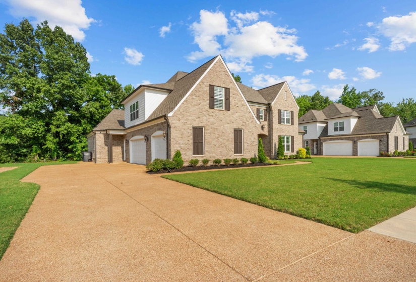 View of front of home with brick siding, driveway, a front lawn, and roof with shingles