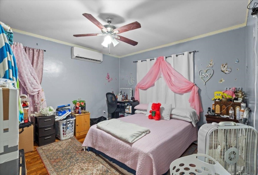 Bedroom with crown molding, wood finished floors, a ceiling fan, and a desk