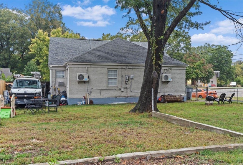 Back of house with brick siding and a shingled roof