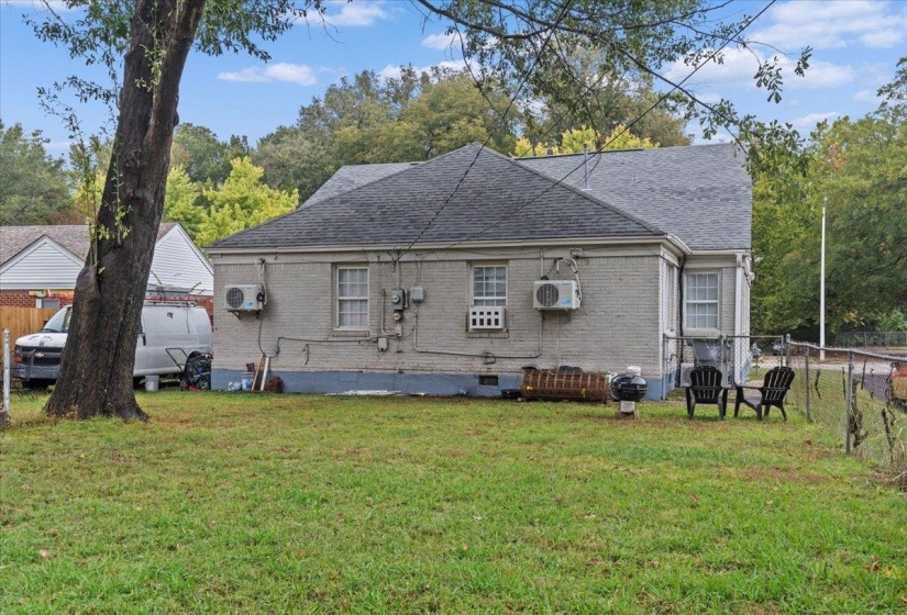 Back of property with brick siding, roof with shingles, and crawl space