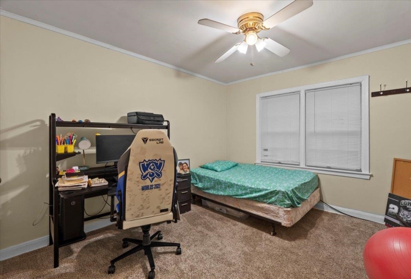 Bedroom featuring ornamental molding, an office area, carpet floors, and ceiling fan