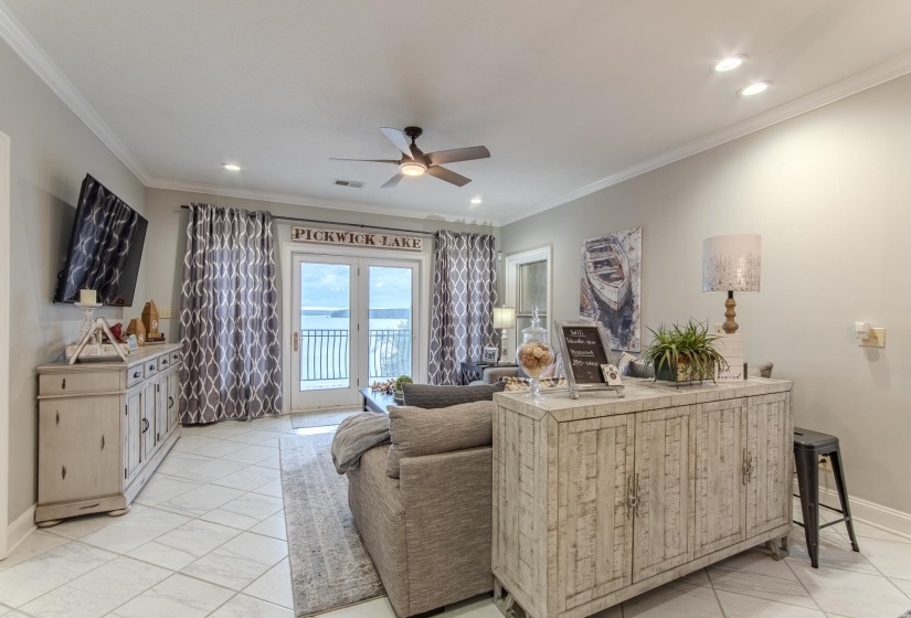 Living area with crown molding, a ceiling fan, recessed lighting, and light marble finish flooring