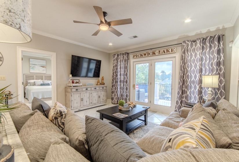 Living room with crown molding, ceiling fan, light tile patterned floors, and recessed lighting