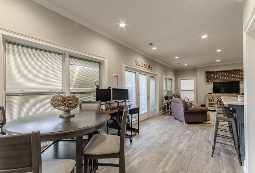 Dining room featuring ornamental molding, light wood-style floors, recessed lighting, and french doors