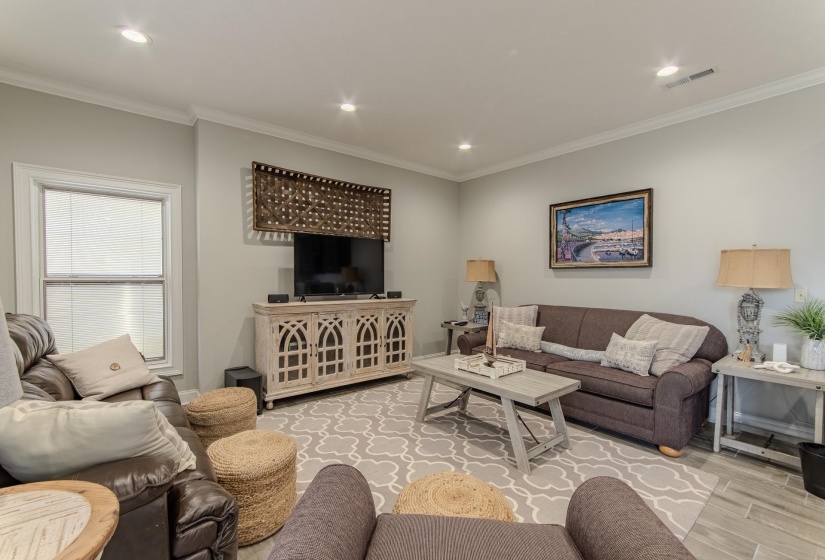 Living room featuring crown molding, recessed lighting, and wood finished floors
