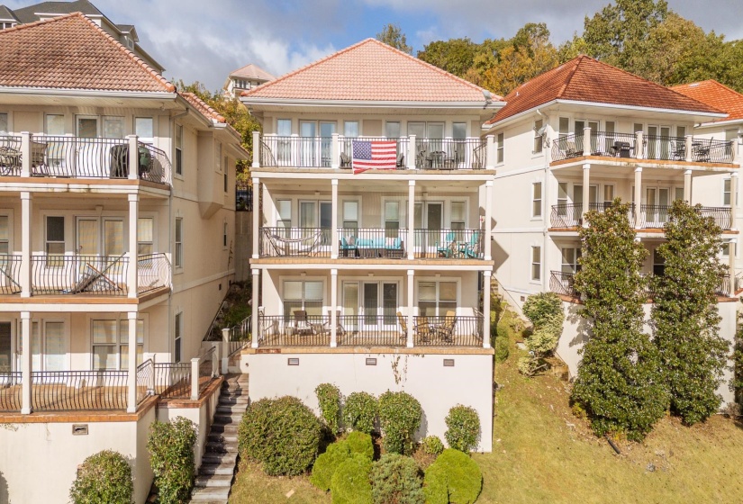 Back of property featuring stairway, stucco siding, and a tile roof