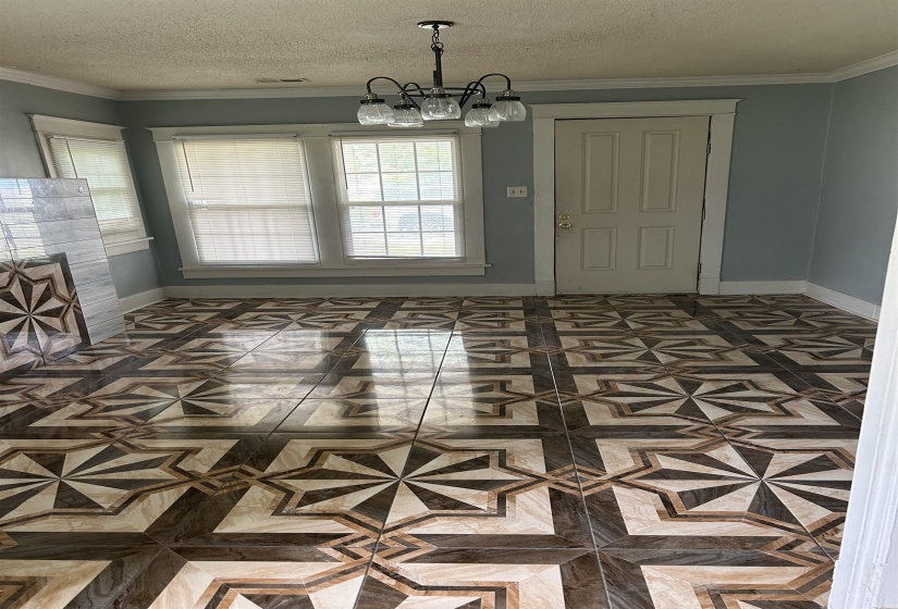 Unfurnished dining area featuring a chandelier, baseboards, ornamental molding, and a textured ceiling