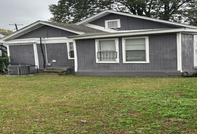 View of front of home featuring a front lawn and roof with shingles