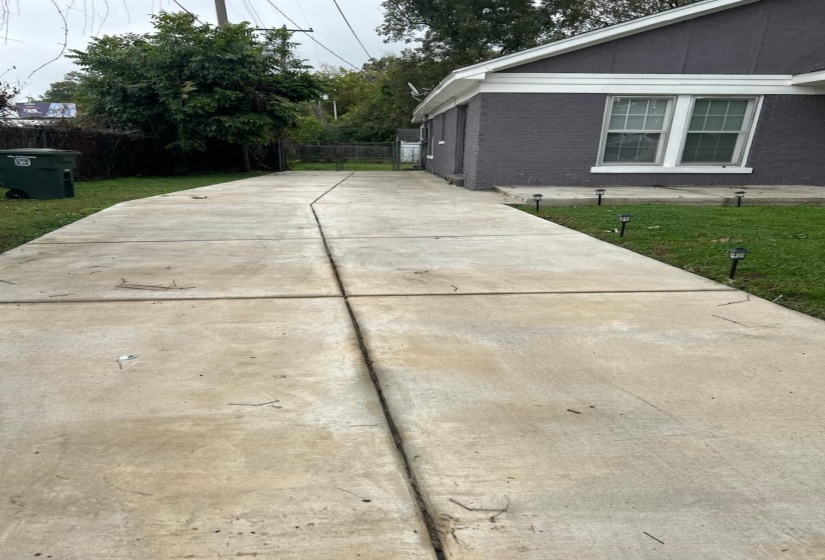 View of side of property featuring brick siding and driveway