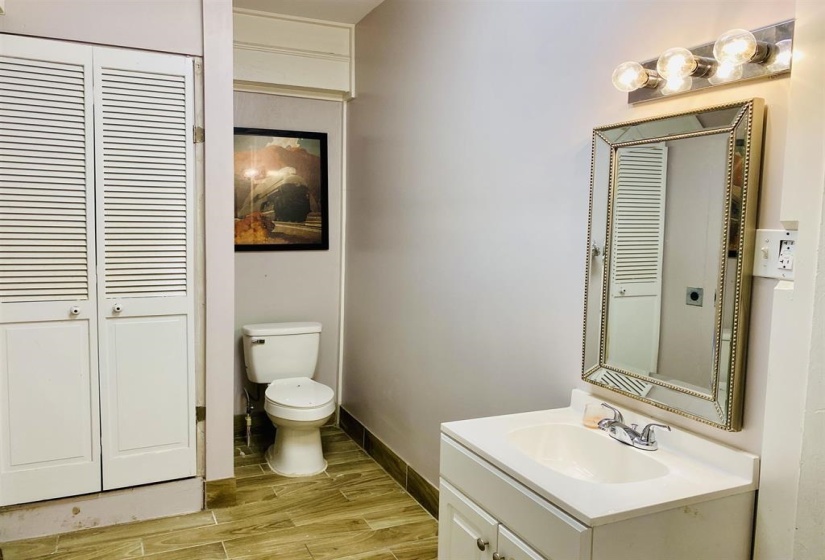 Half bath featuring a closet, wood tiled floors, and vanity