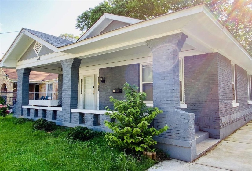 View of side of property with brick siding and a porch