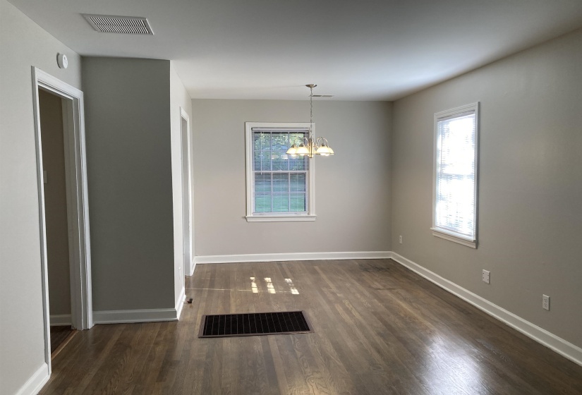 Unfurnished dining area with dark wood-style flooring and a chandelier