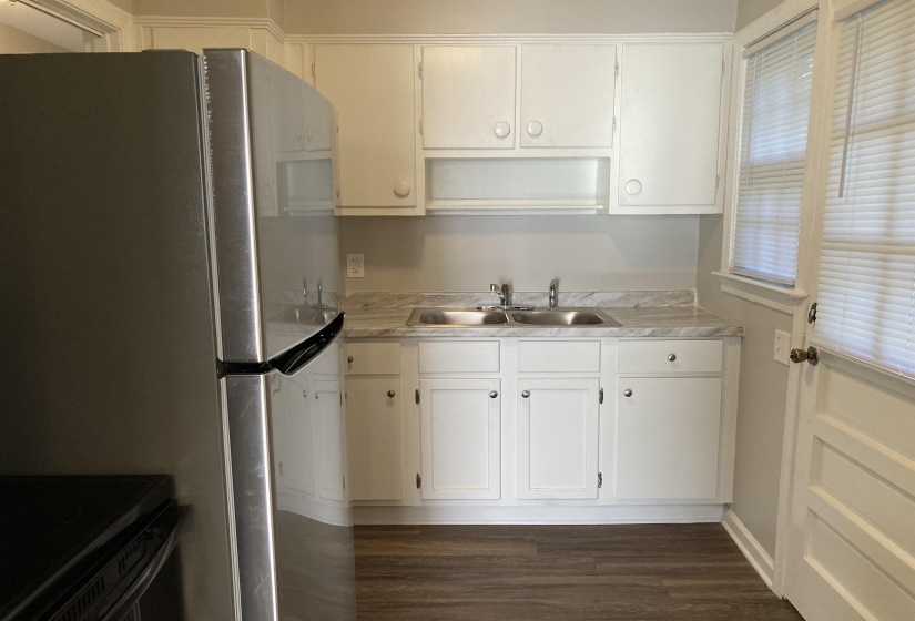 Kitchen featuring light countertops, dark wood-style flooring, white cabinetry, and black range with electric cooktop