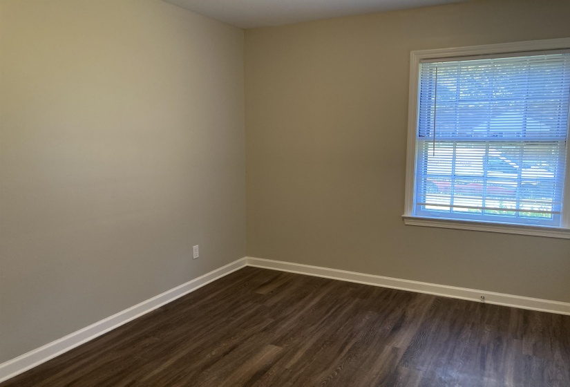 Unfurnished room featuring baseboards and dark wood-type flooring