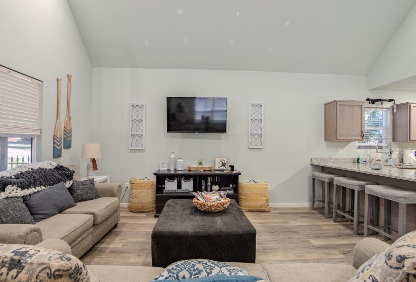 Living area featuring vaulted ceiling and light wood-style floors