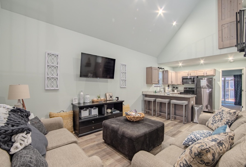 Living area featuring high vaulted ceiling and light wood-style flooring