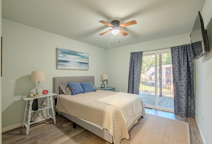 Bedroom featuring wood finished floors, access to exterior, and ceiling fan