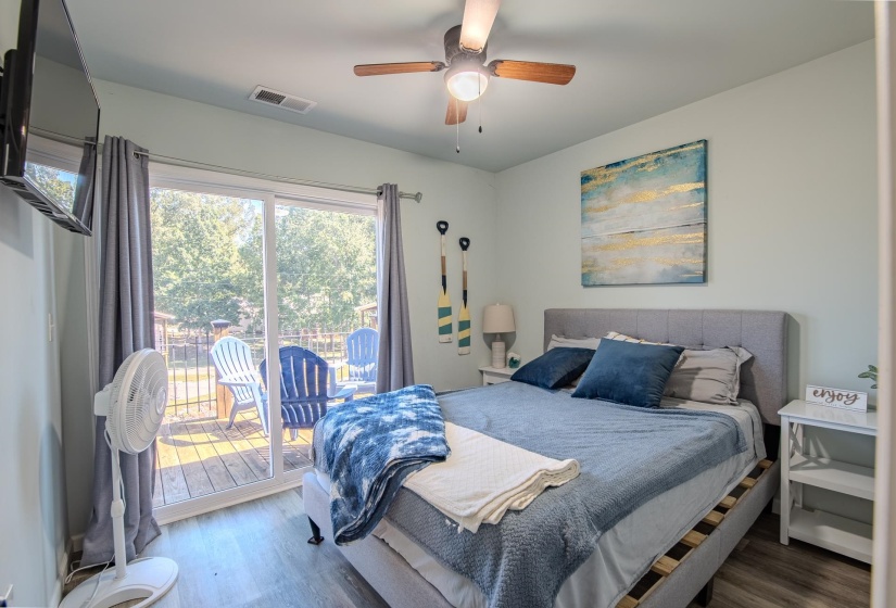 Bedroom featuring wood finished floors, a ceiling fan, and access to exterior