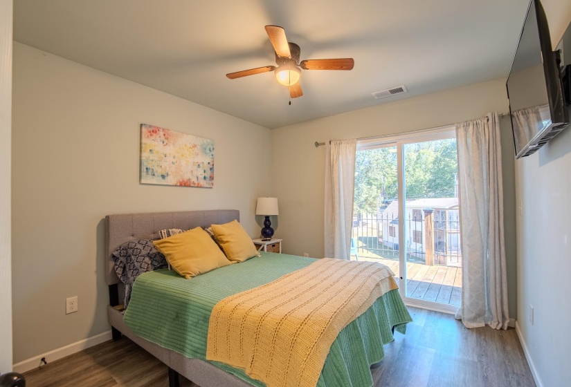 Bedroom featuring wood finished floors, access to outside, and ceiling fan