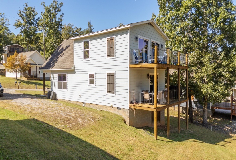 Rear view of property featuring a yard, crawl space, and a shingled roof