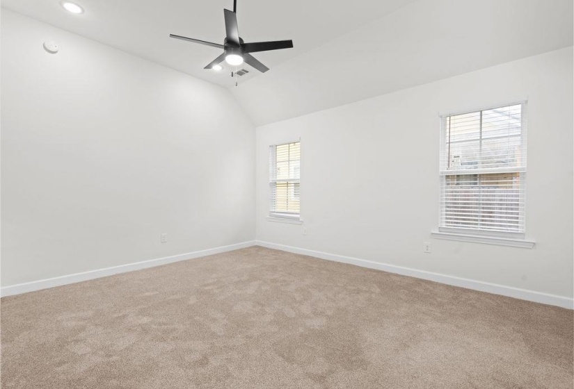 Spare room with light colored carpet, lofted ceiling, and ceiling fan