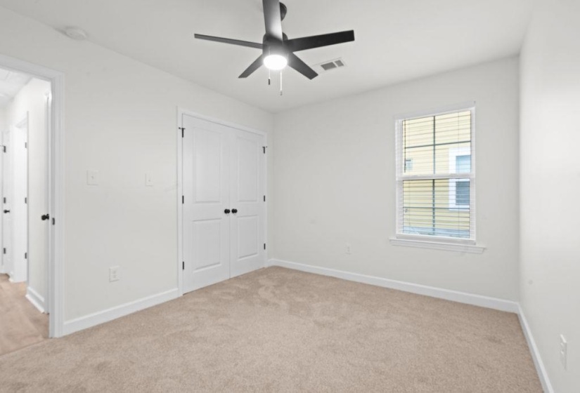 Unfurnished bedroom with light colored carpet, a closet, and a ceiling fan