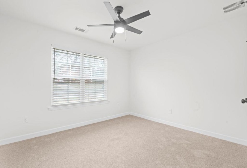 Spare room with light carpet and a ceiling fan