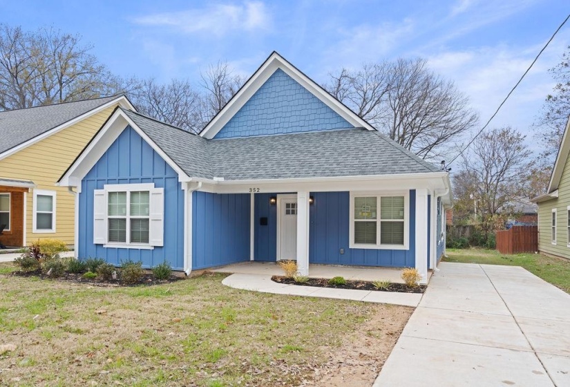 Bungalow-style house featuring board and batten siding, roof with shingles, a front lawn, and a porch