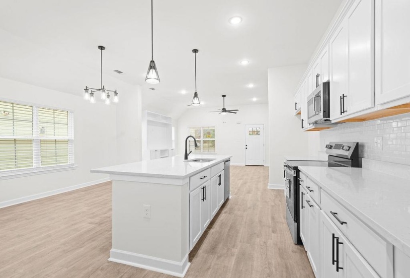 Kitchen with appliances with stainless steel finishes, white cabinets, pendant lighting, light stone counters, and recessed lighting