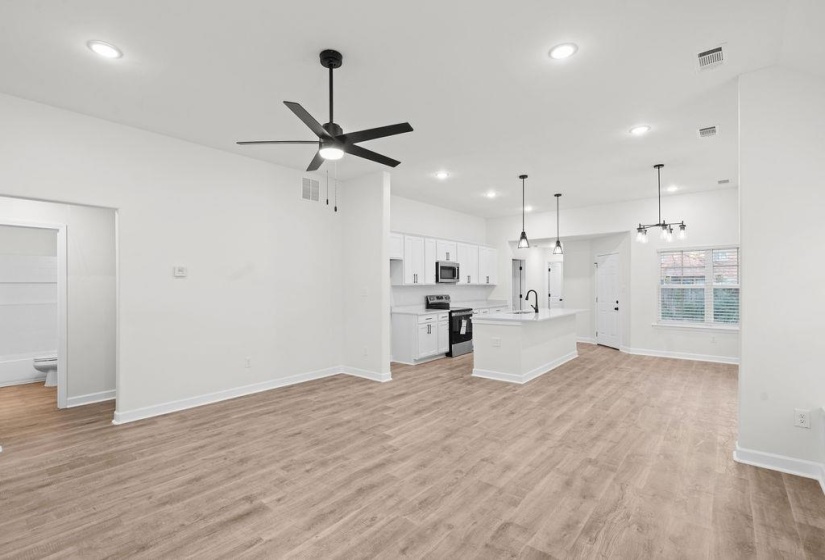 Unfurnished living room featuring light wood-type flooring, ceiling fan, and recessed lighting