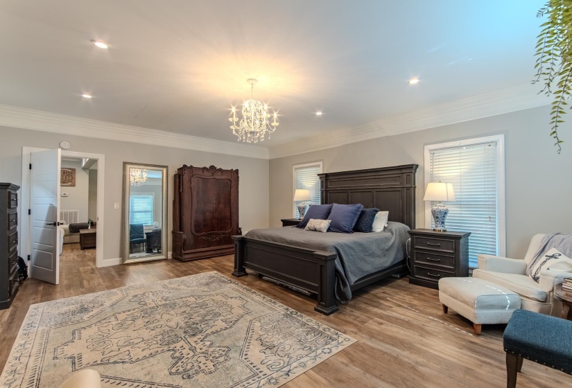 Bedroom featuring a chandelier, light wood-style flooring, ornamental molding, and recessed lighting