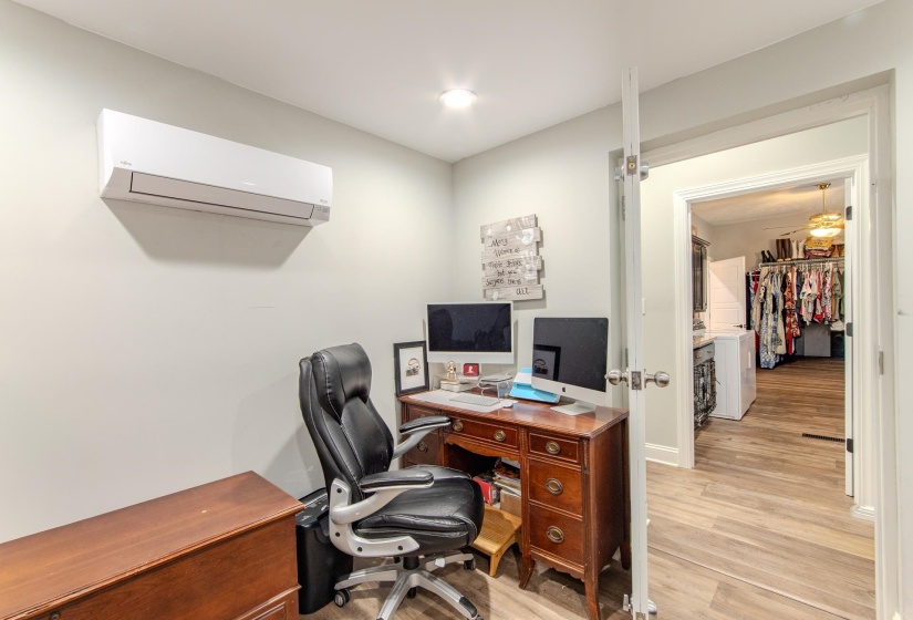 Office with light wood finished floors and a wall mounted AC