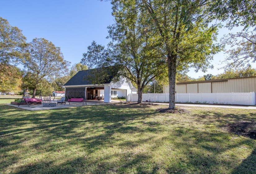 Back of house with a patio and an outbuilding