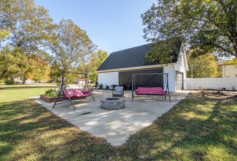 View of patio / terrace featuring an outdoor fire pit and an outbuilding